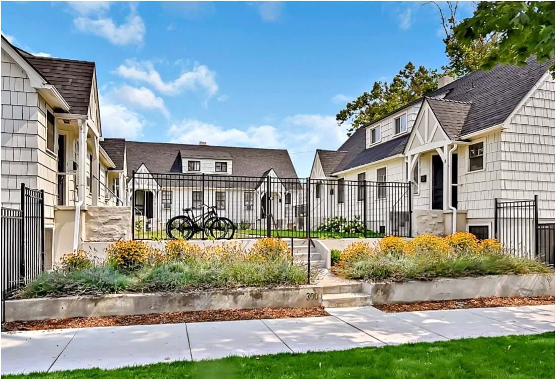 Homes around a courtyard gated in. With landscaping leading to sidewalk.