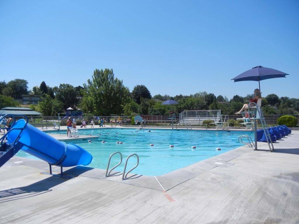 Borah pool with small blue slide and diving board with blue skies and clear water