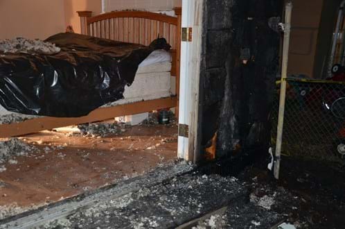 Interior of bedroom and hallway of house with significant fire damage