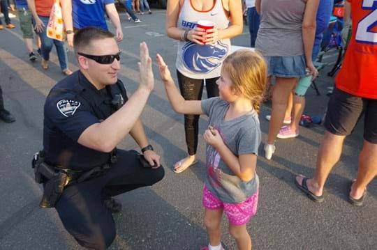 Policeman giving little girl high five