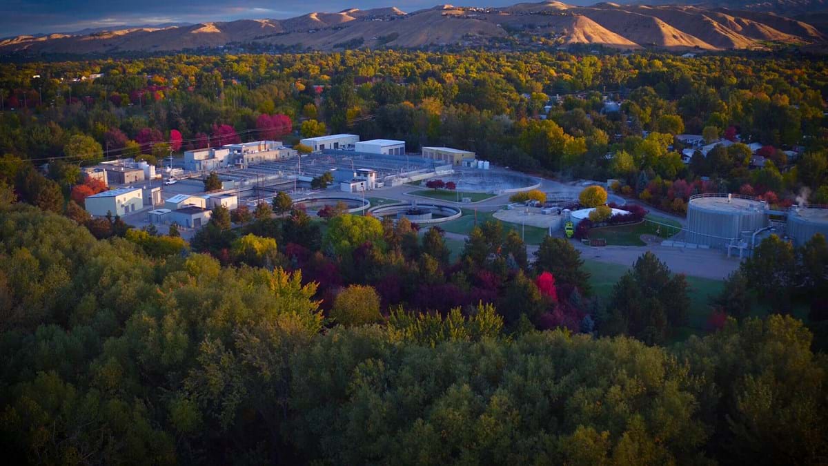 Aerial view of Lander Street Wastewater Treatment Facility surrounded by trees during sunset