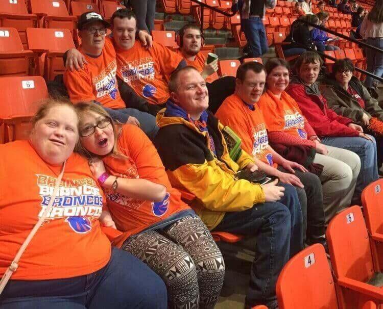 group of people dressed in orange watching boise state basketball game